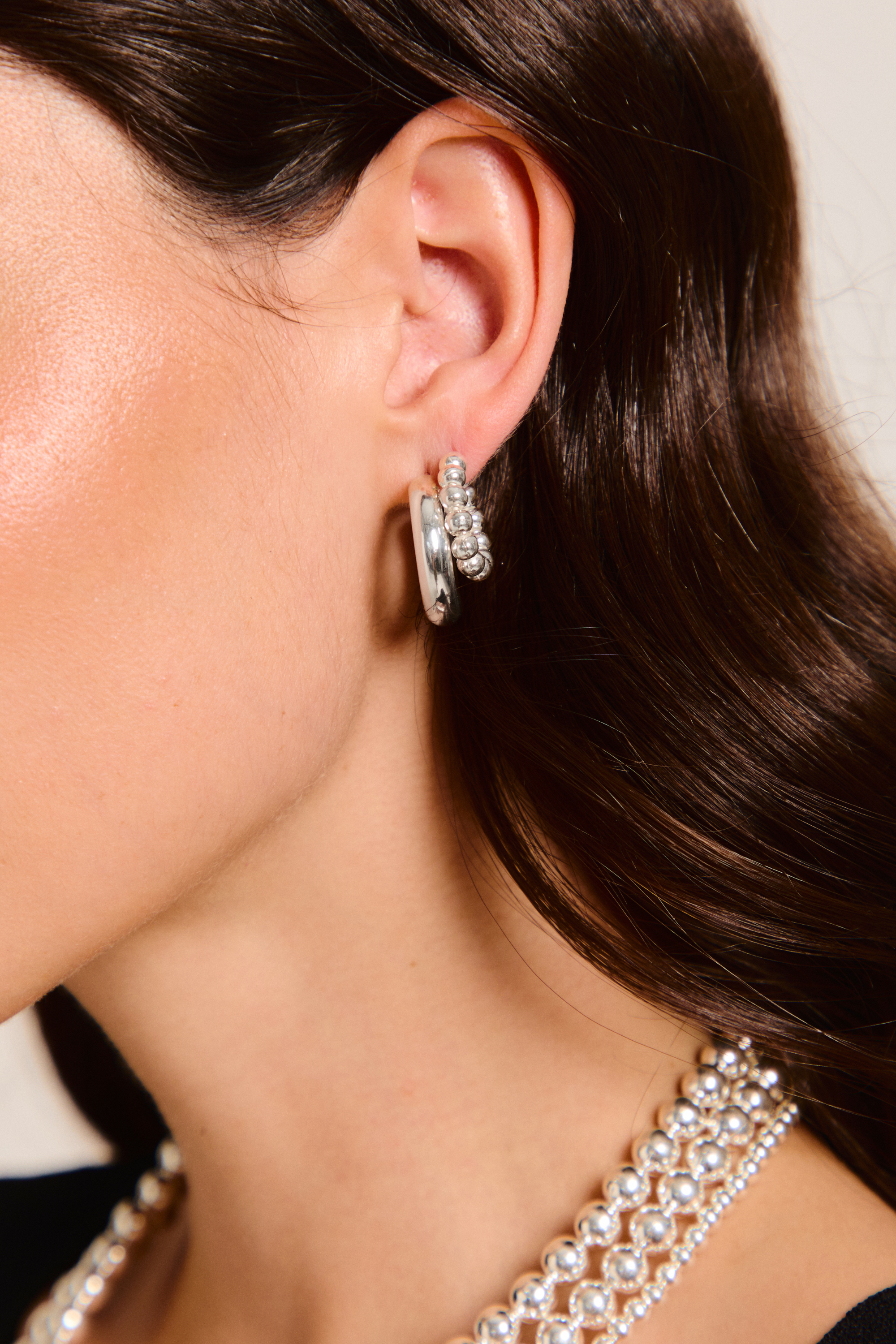 Model wearing two handmade earrings.