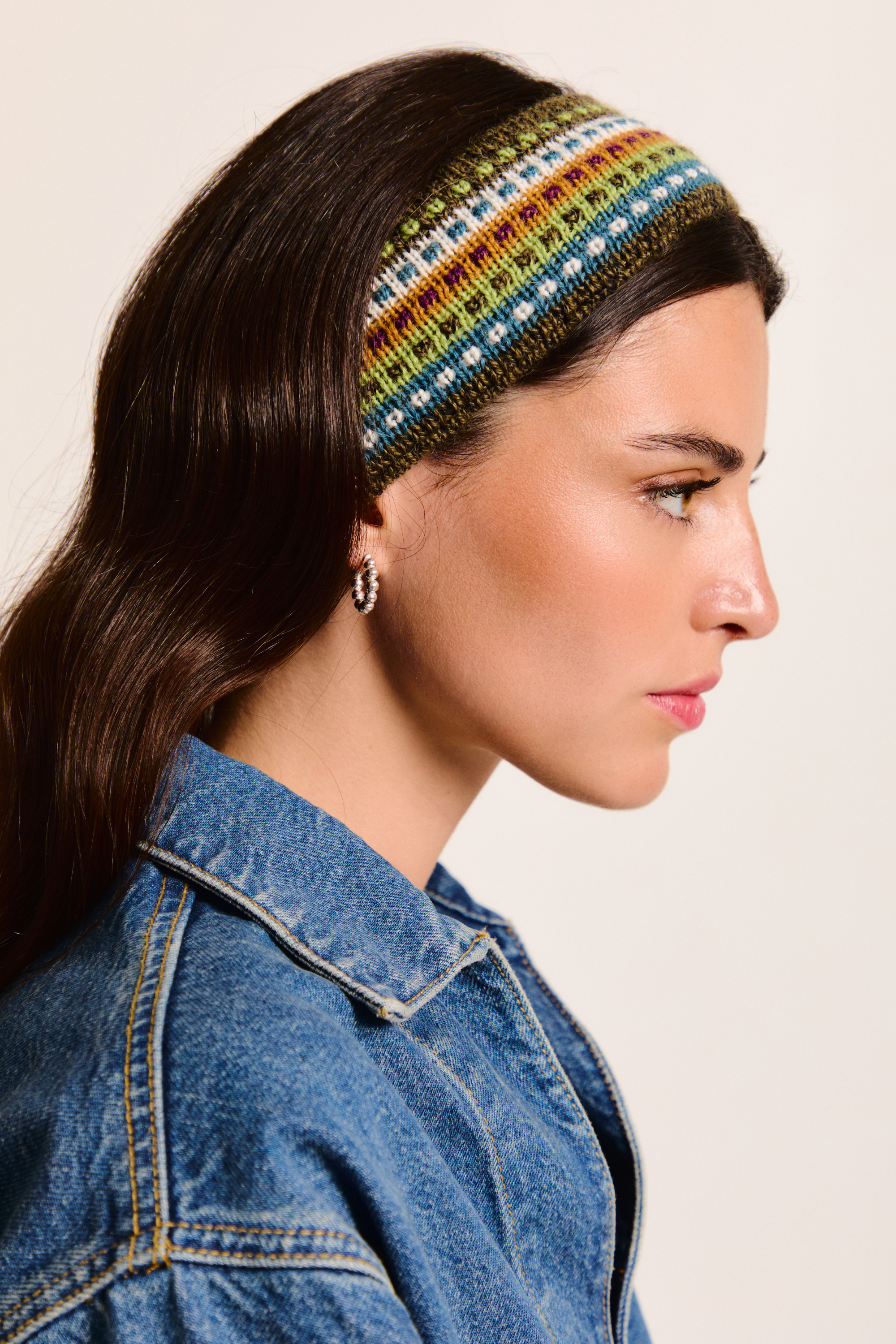 Model wearing a colorful handmade headband on a neutral background.
