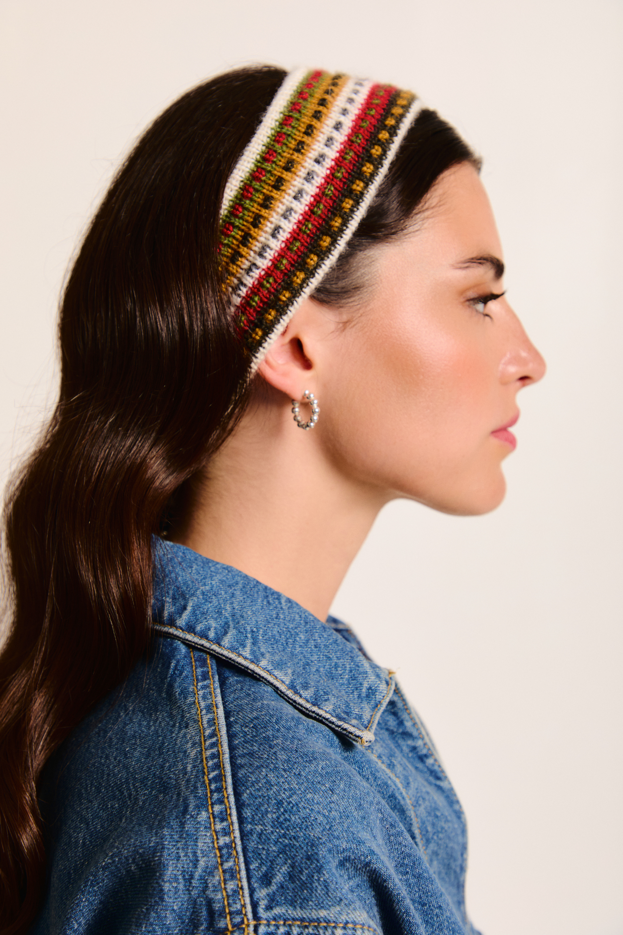 Model wearing a colorful handmade headband on a neutral background.