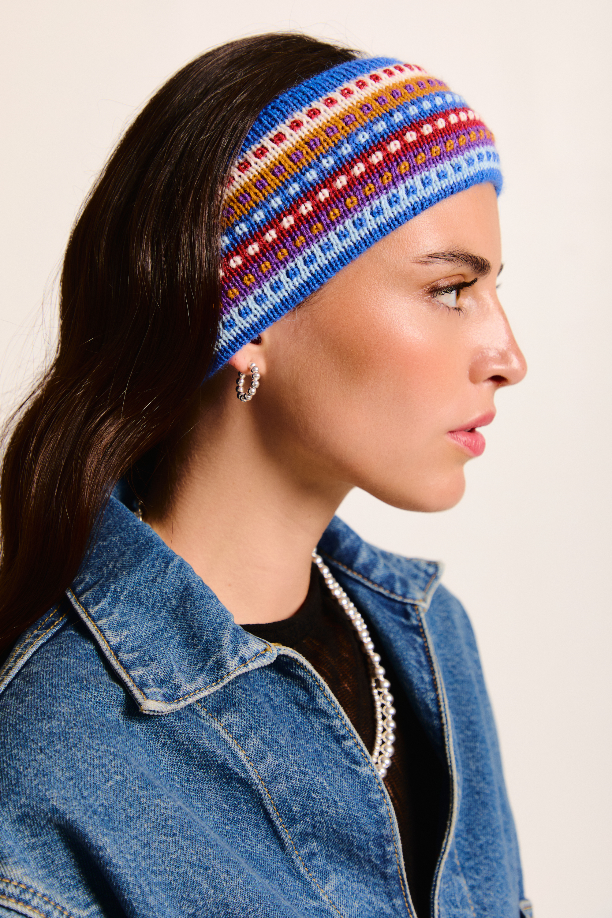 Model wearing a colorful handmade headband on a neutral background.
