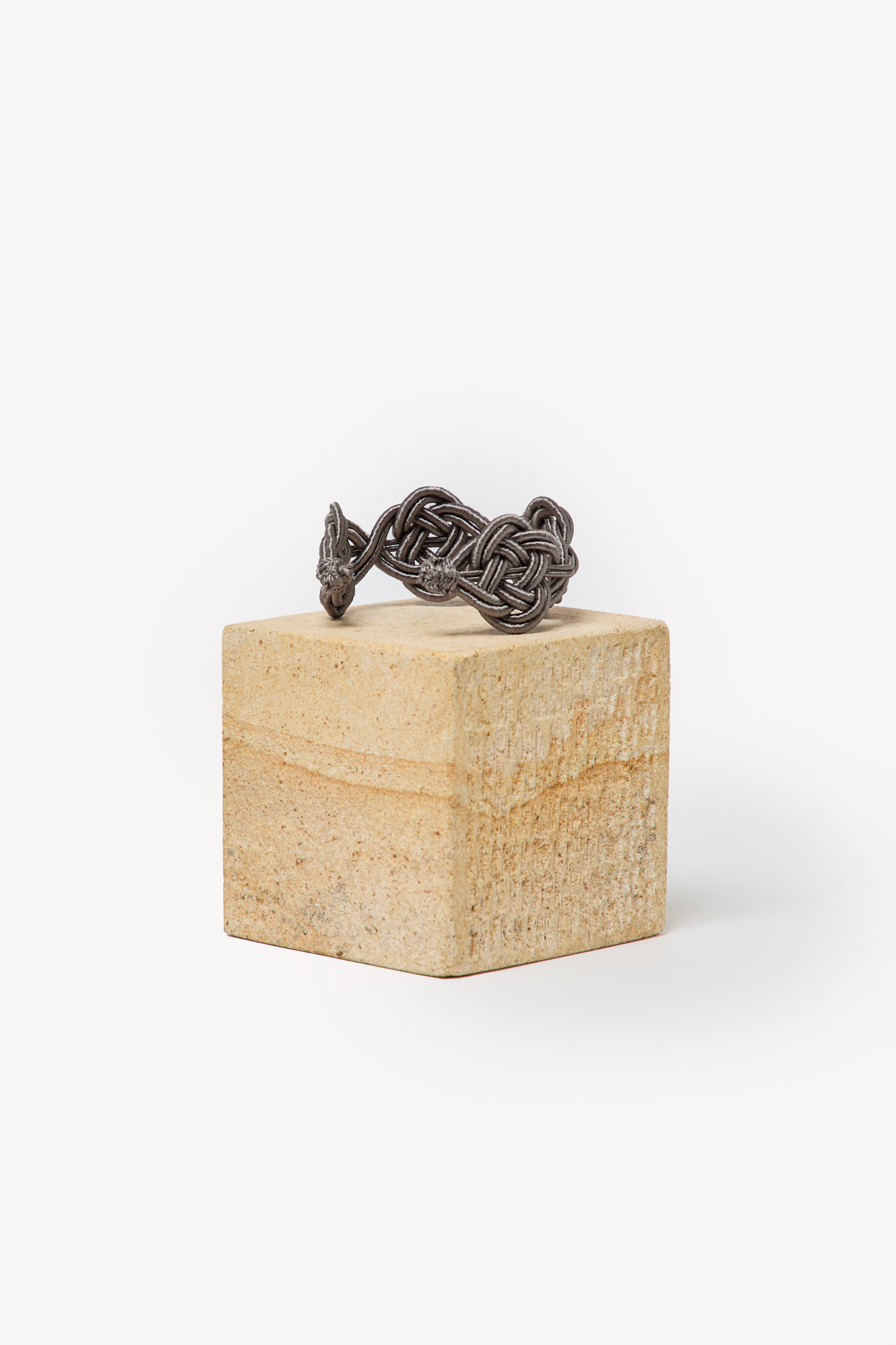 Handmade Nouba bracelet on a box with a neutral background.