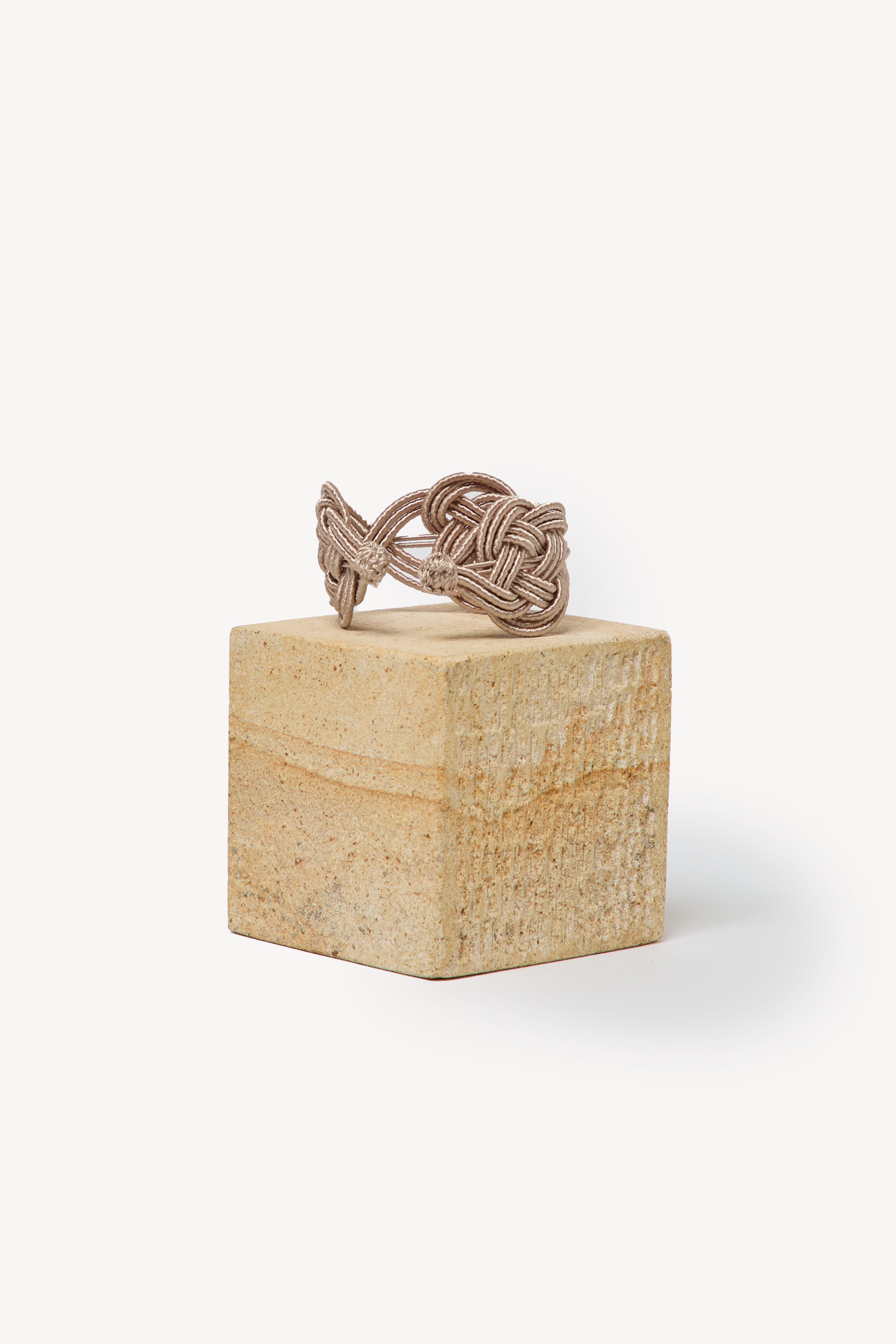 Handmade Nouba bracelet on a box with a neutral background.