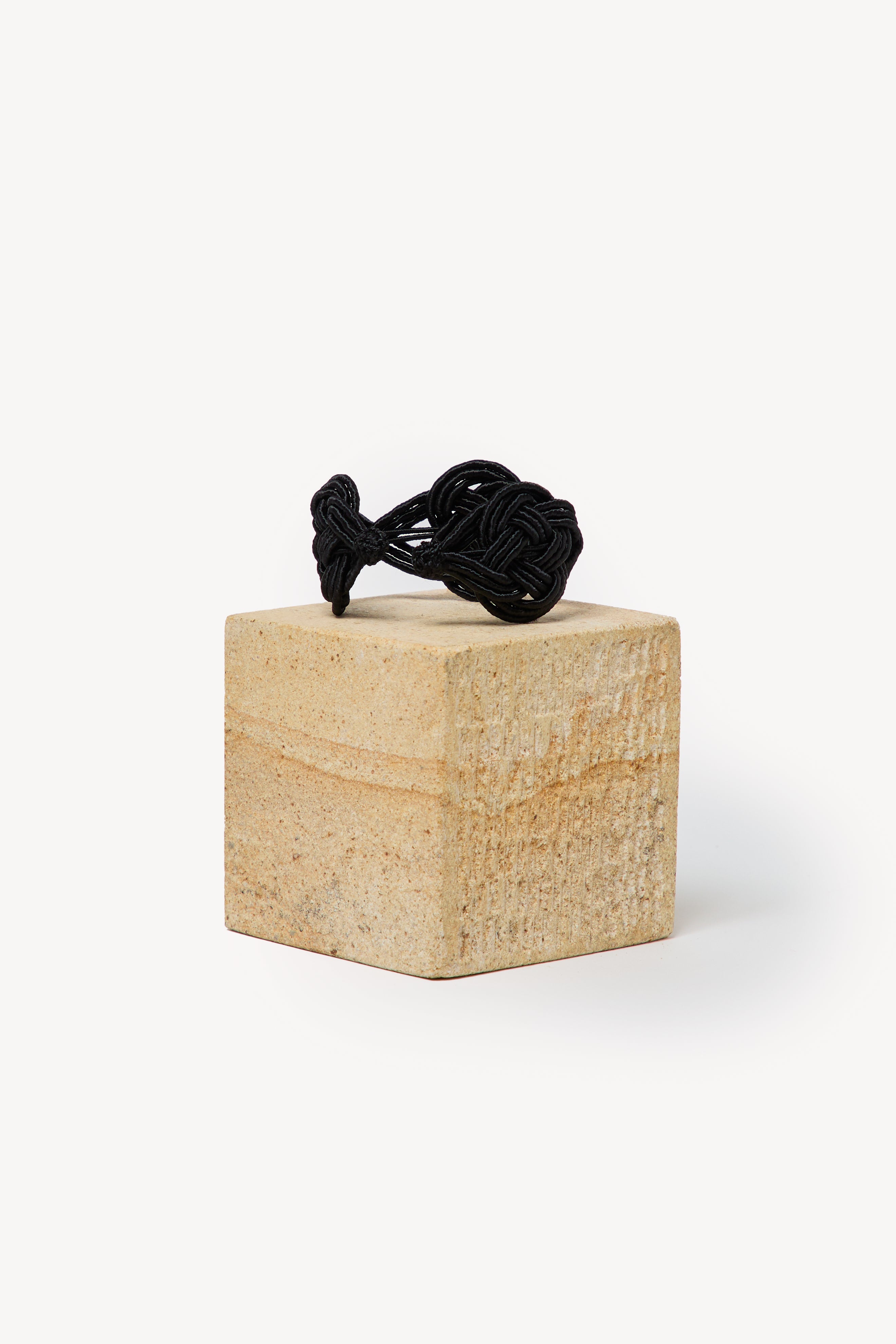 Handmade Nouba bracelet on a box with a neutral background.