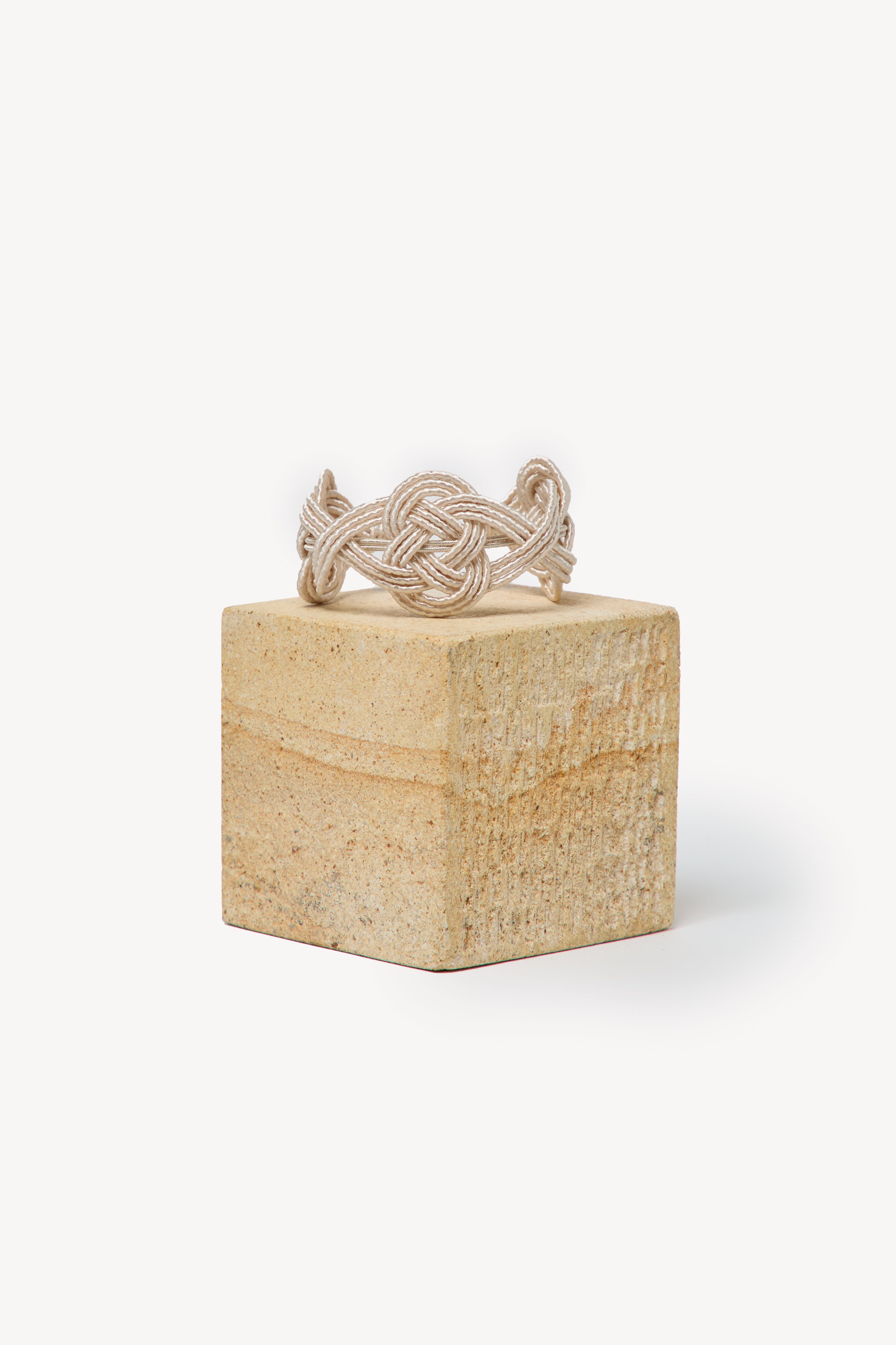 Handmade Nouba bracelet on a box with a neutral background.