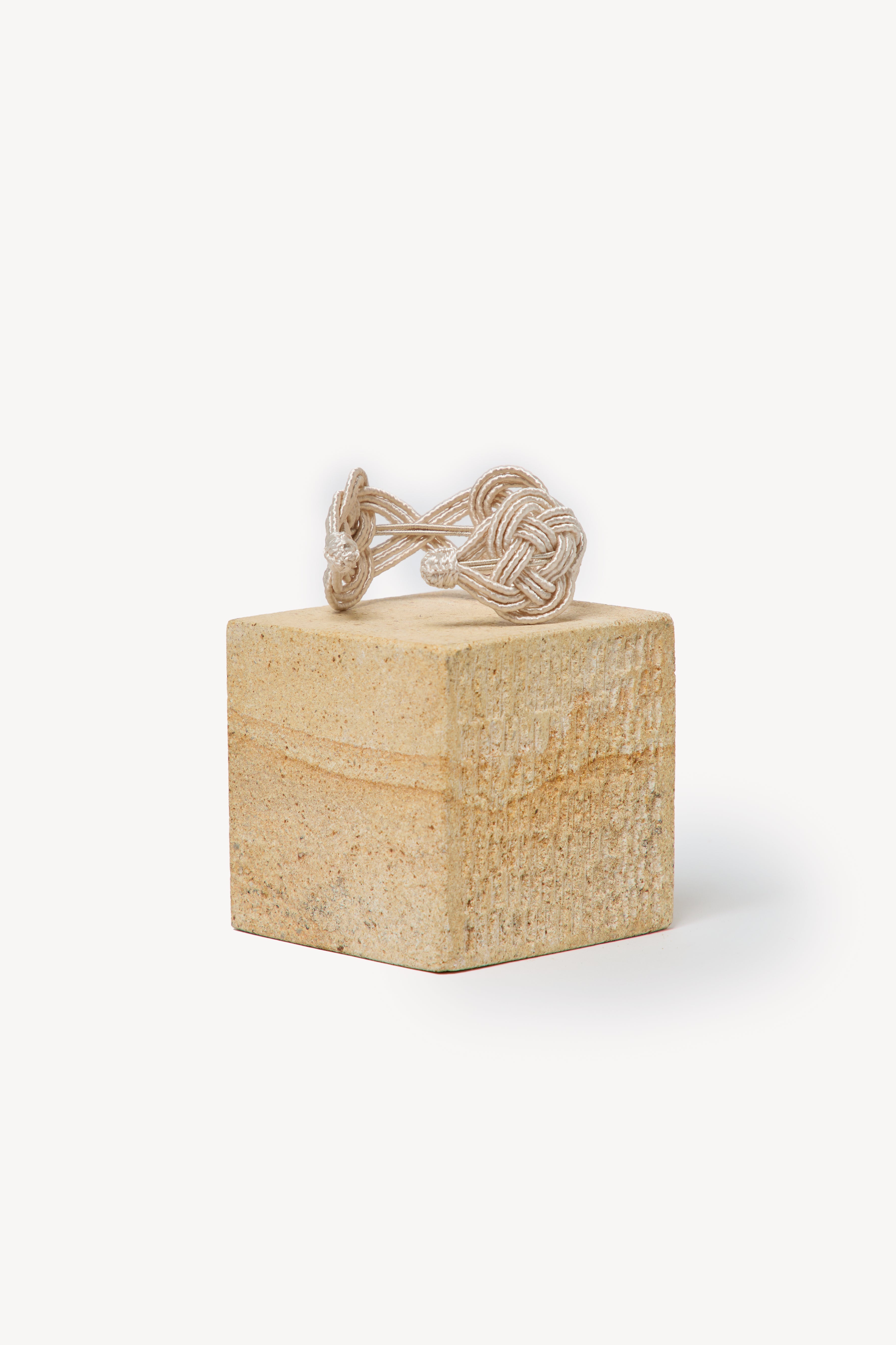 Handmade Nouba bracelet on a box with a neutral background.