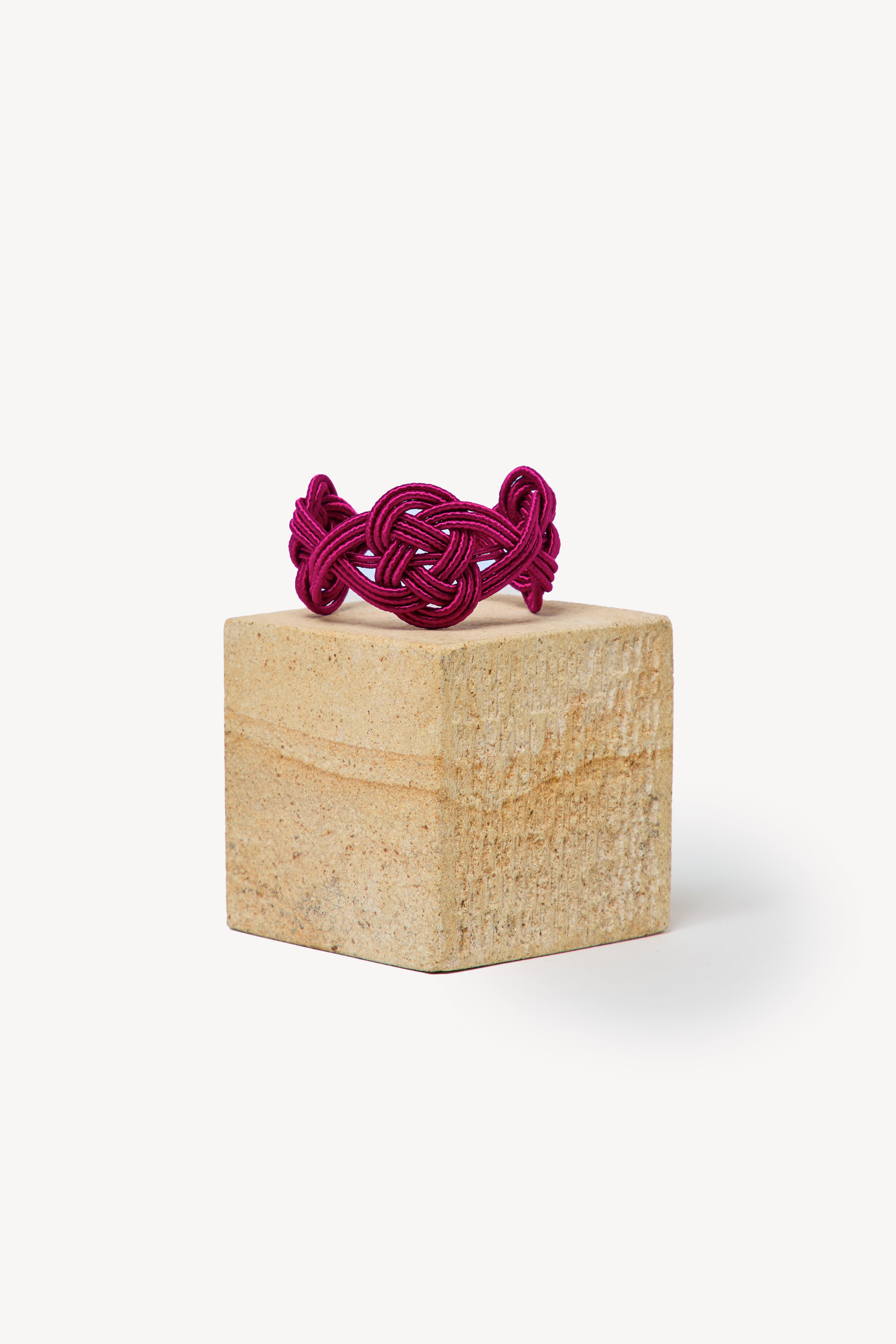 Handmade Nouba bracelet on a box with a neutral background.