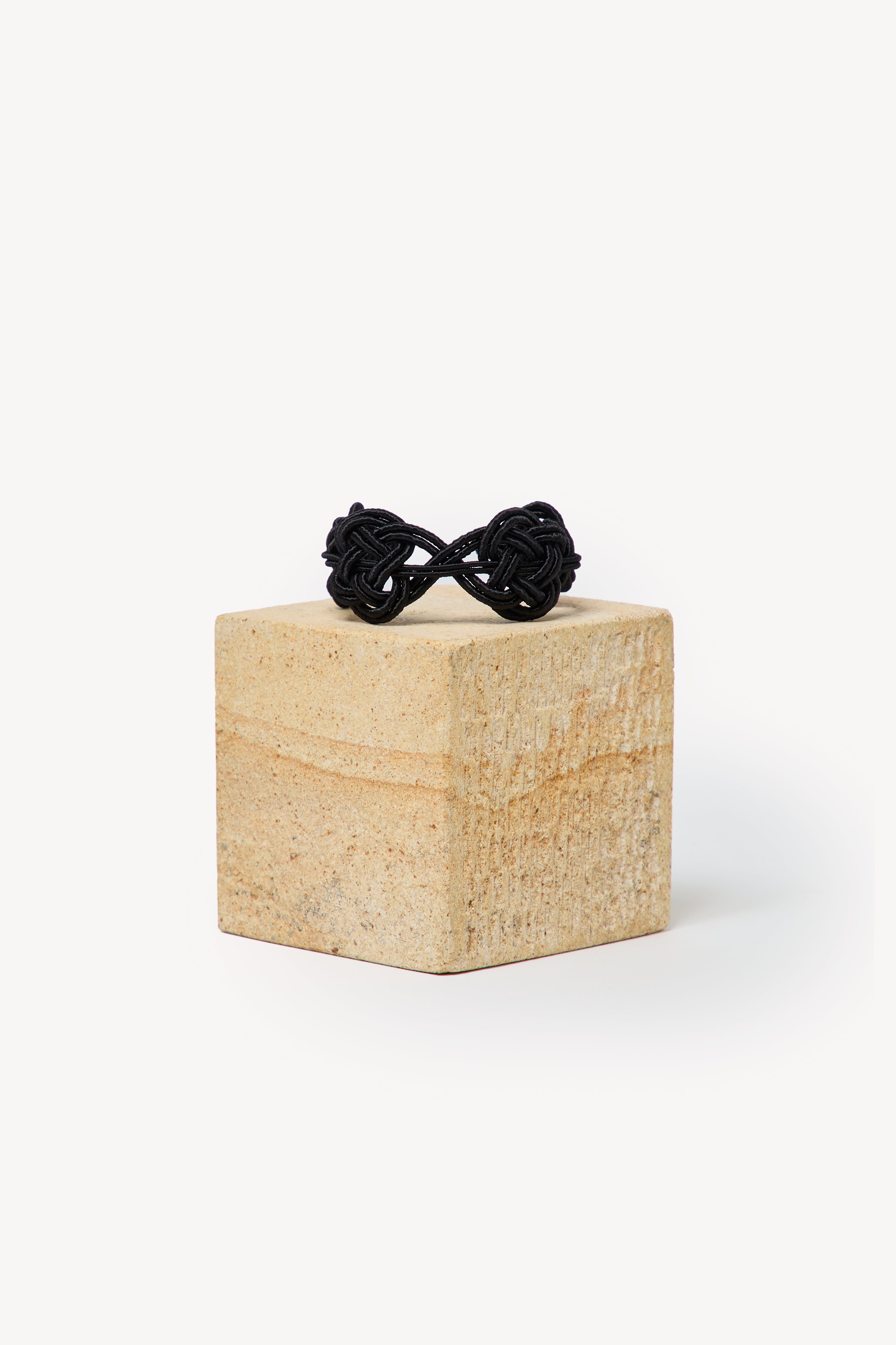 Handmade Nouba bracelet on a box with a neutral background.