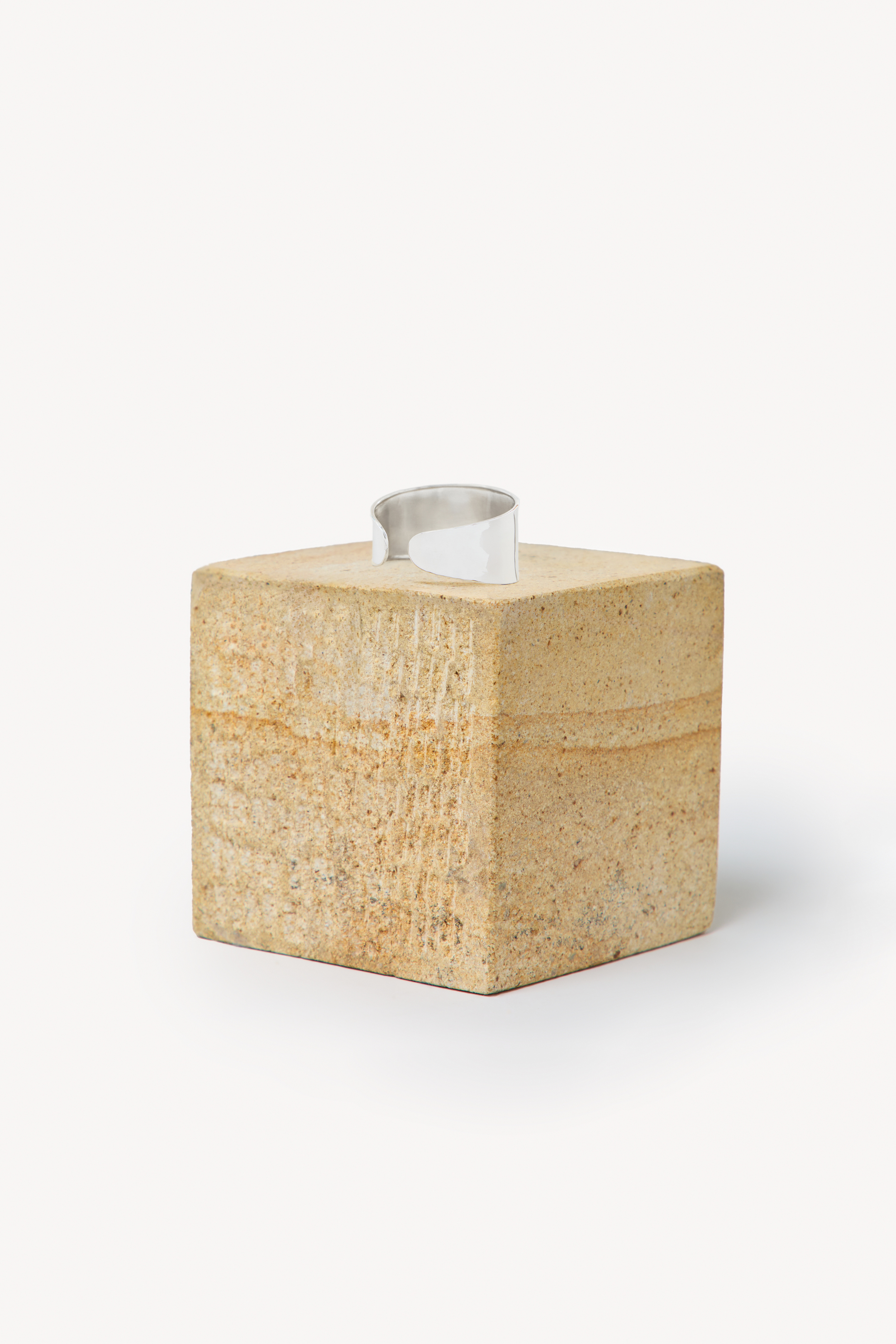 Handmade bracelet placed on a box with a neutral background