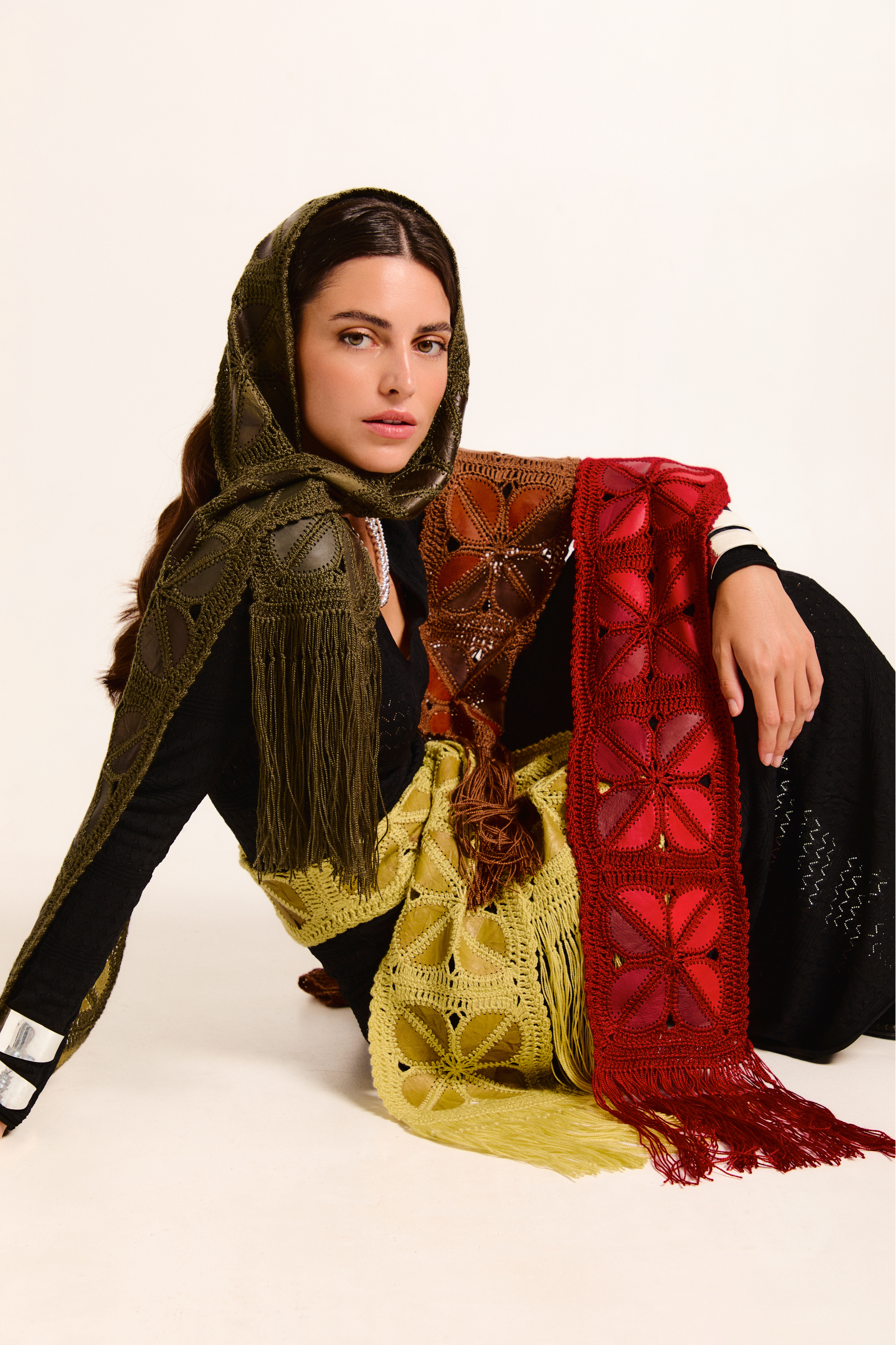 Model wearing three handmade scarves on a neutral background