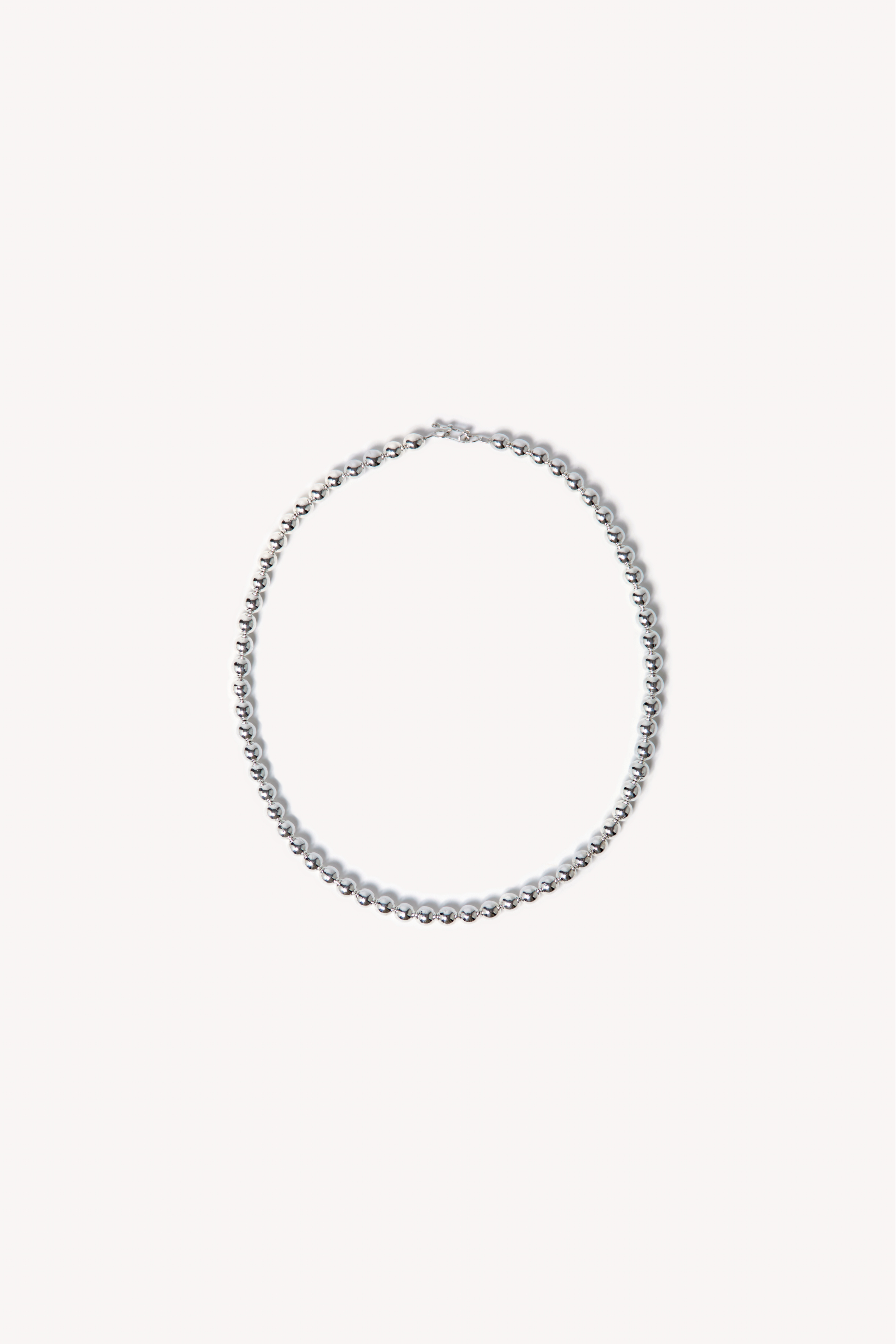 Handcrafted necklace with beads on a neutral background.