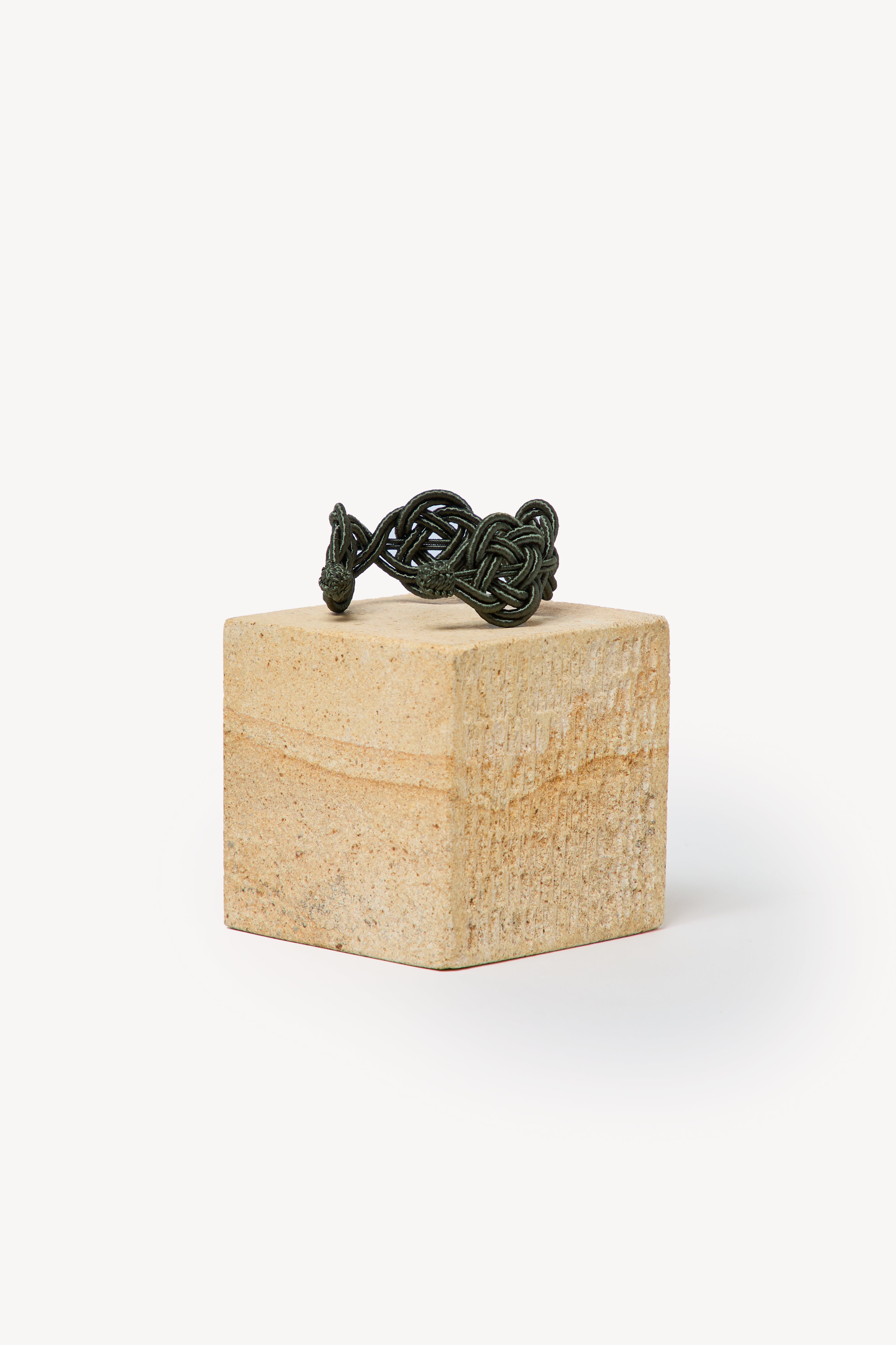 Handmade Nouba bracelet on a box with a neutral background.