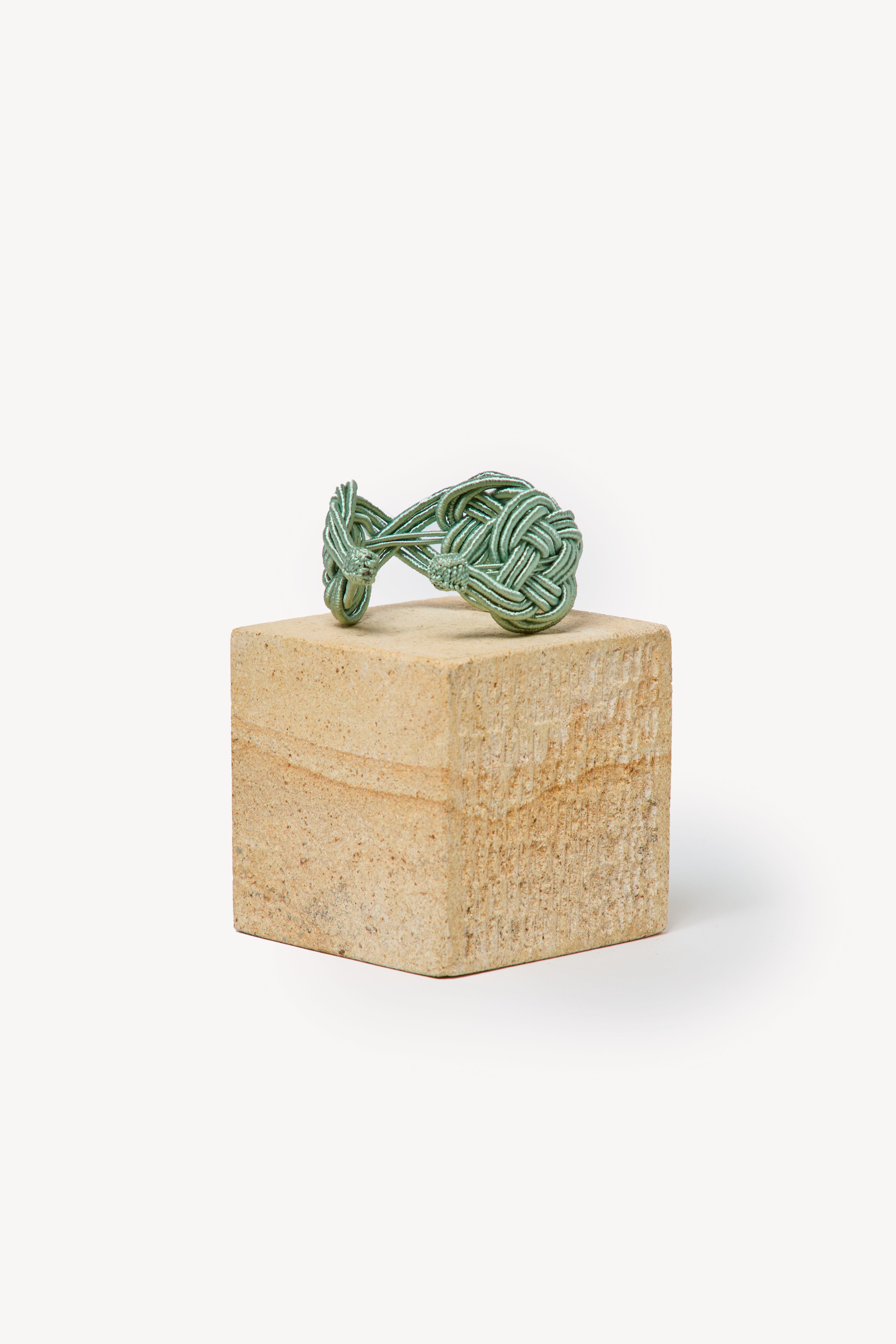 Handmade Nouba bracelet on a box with a neutral background.