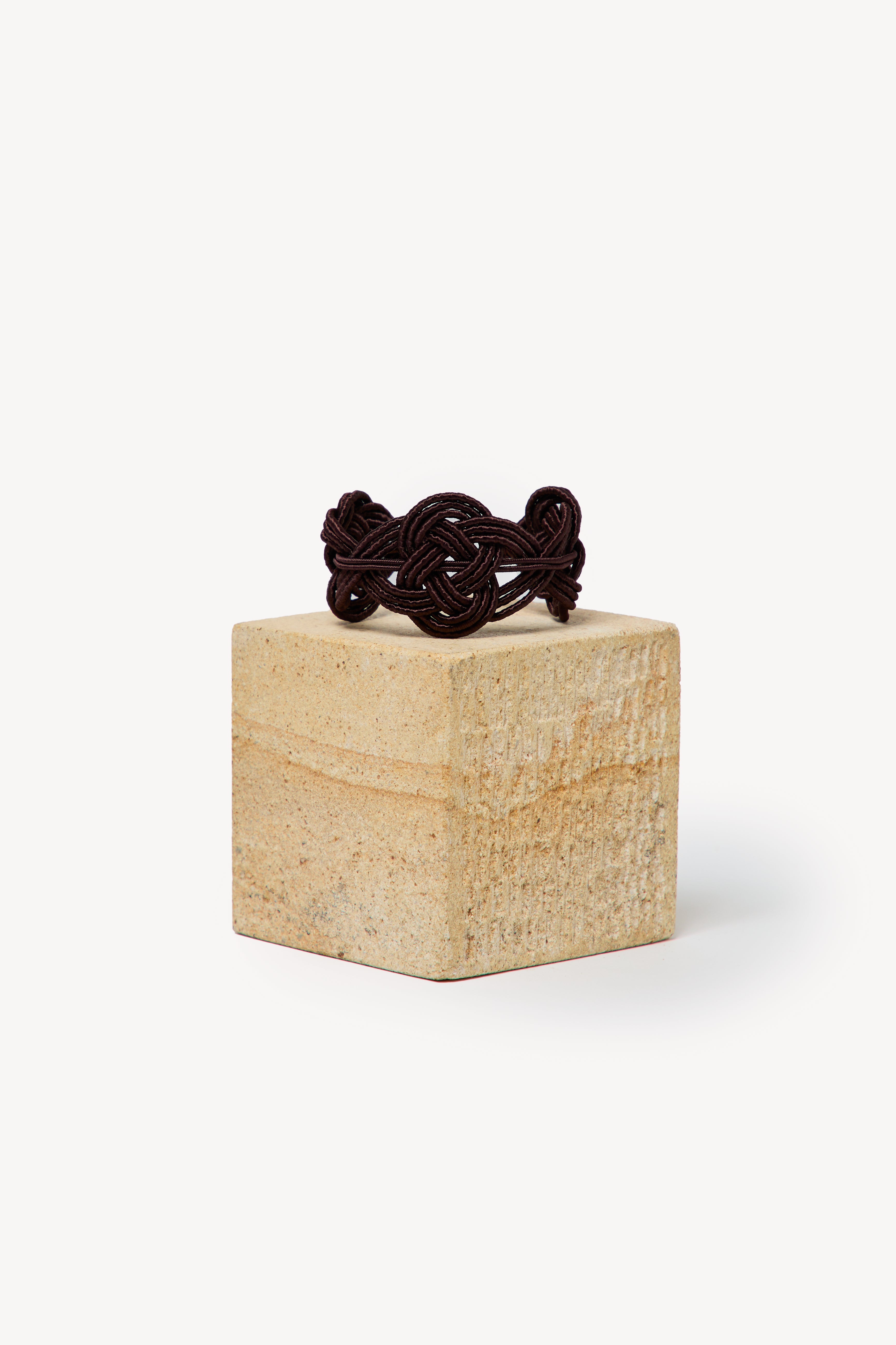 Handmade Nouba bracelet on a box with a neutral background.