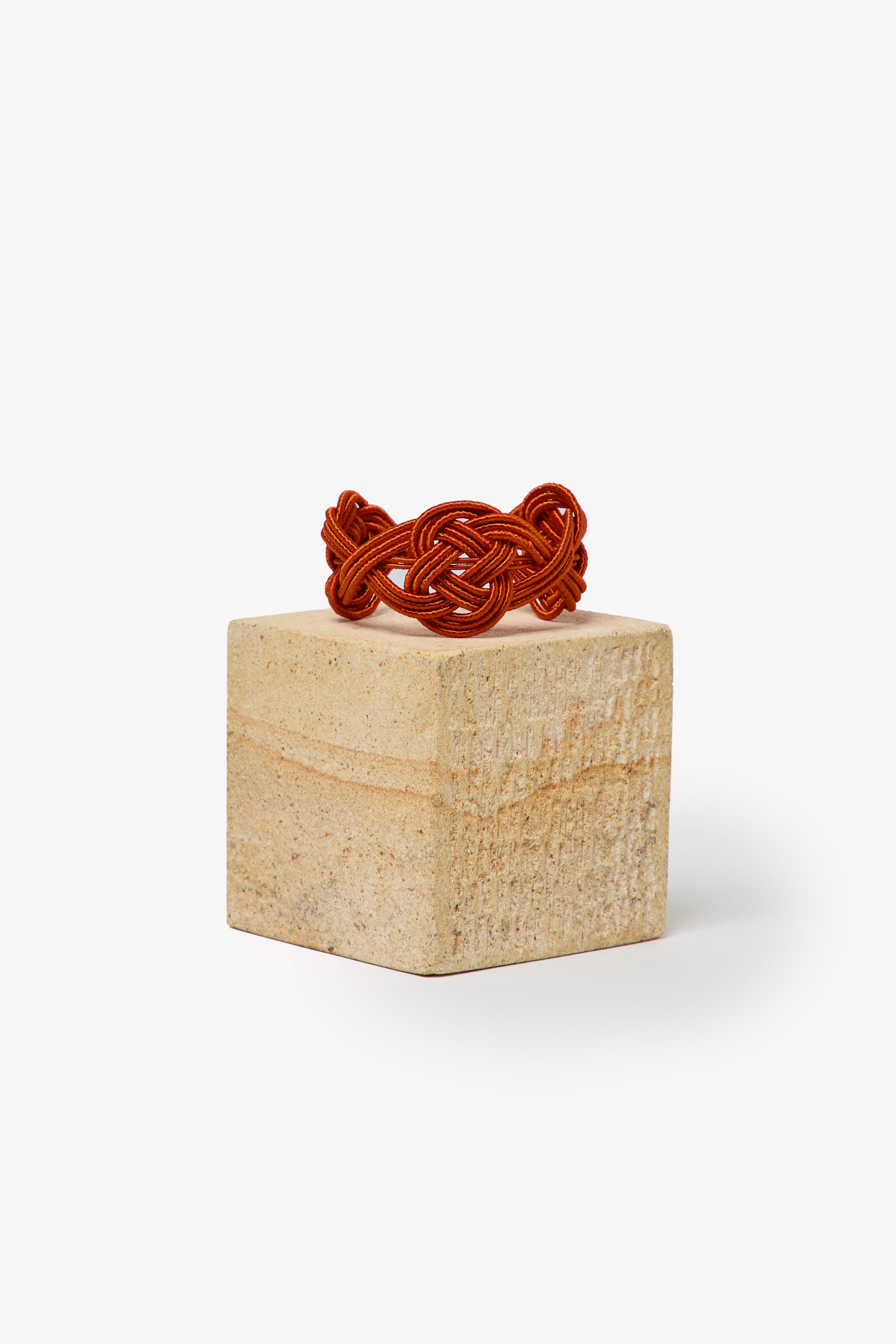 Handmade Nouba bracelet on a box with a neutral background.