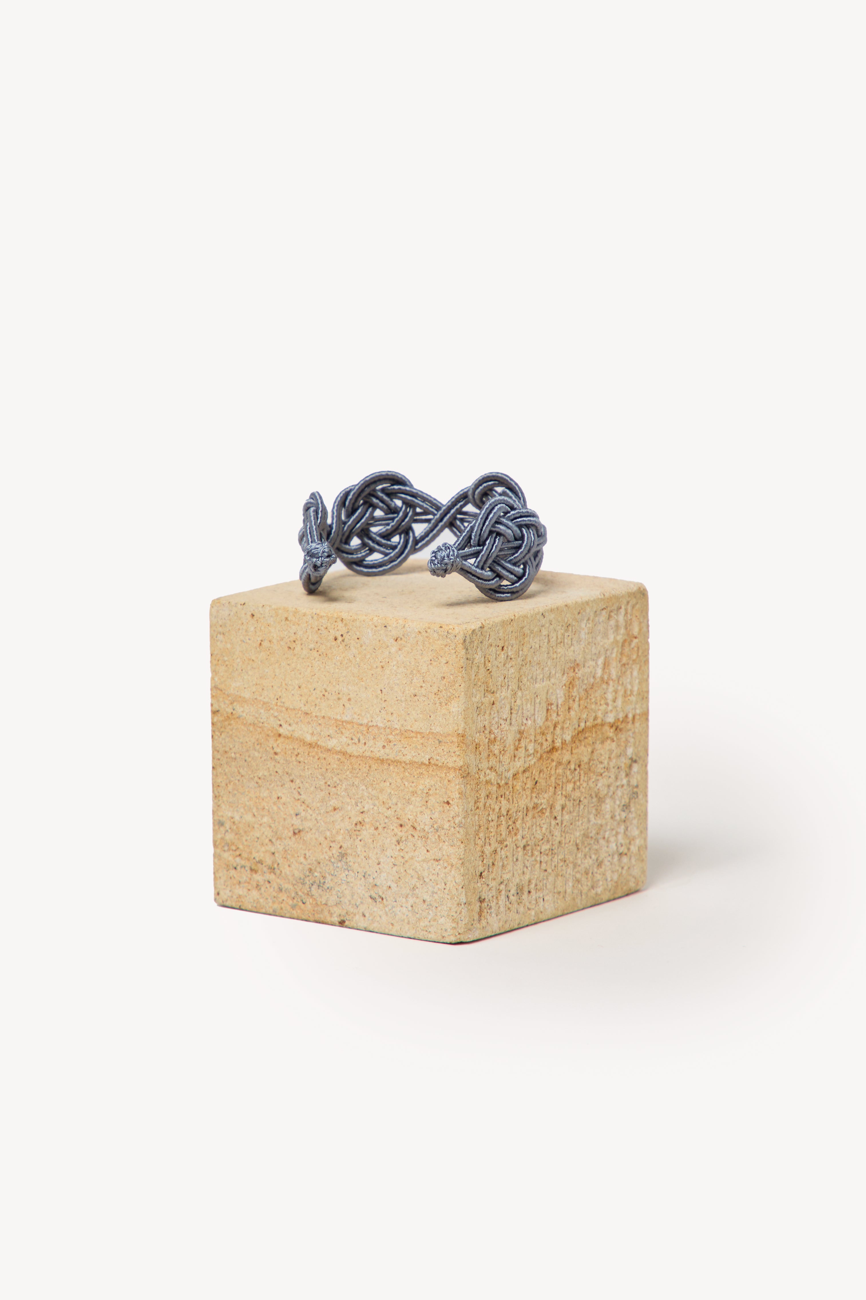Handmade Nouba bracelet on a box with a neutral background.