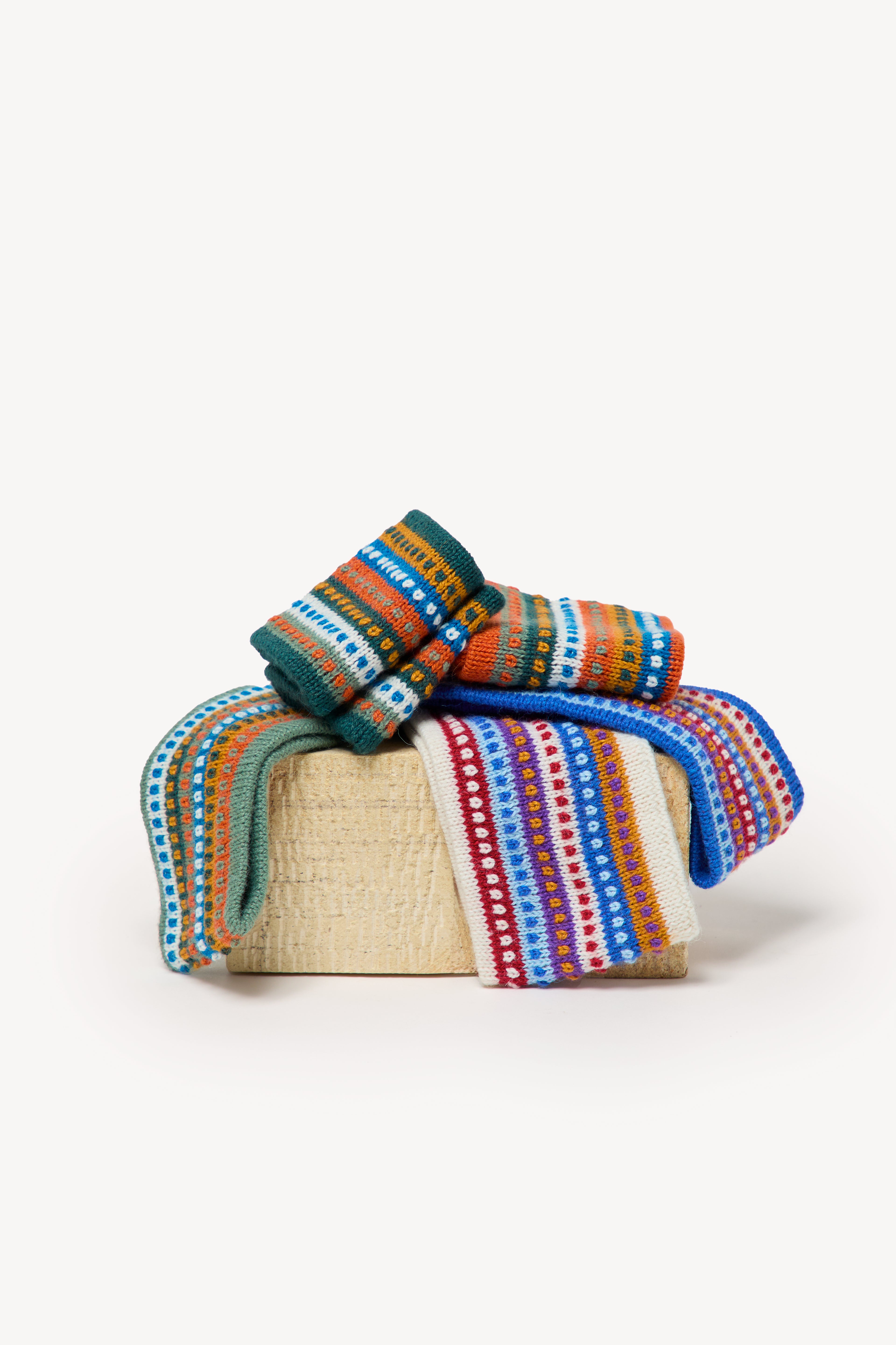 Colorful handmade headbands inside a box on a neutral background.