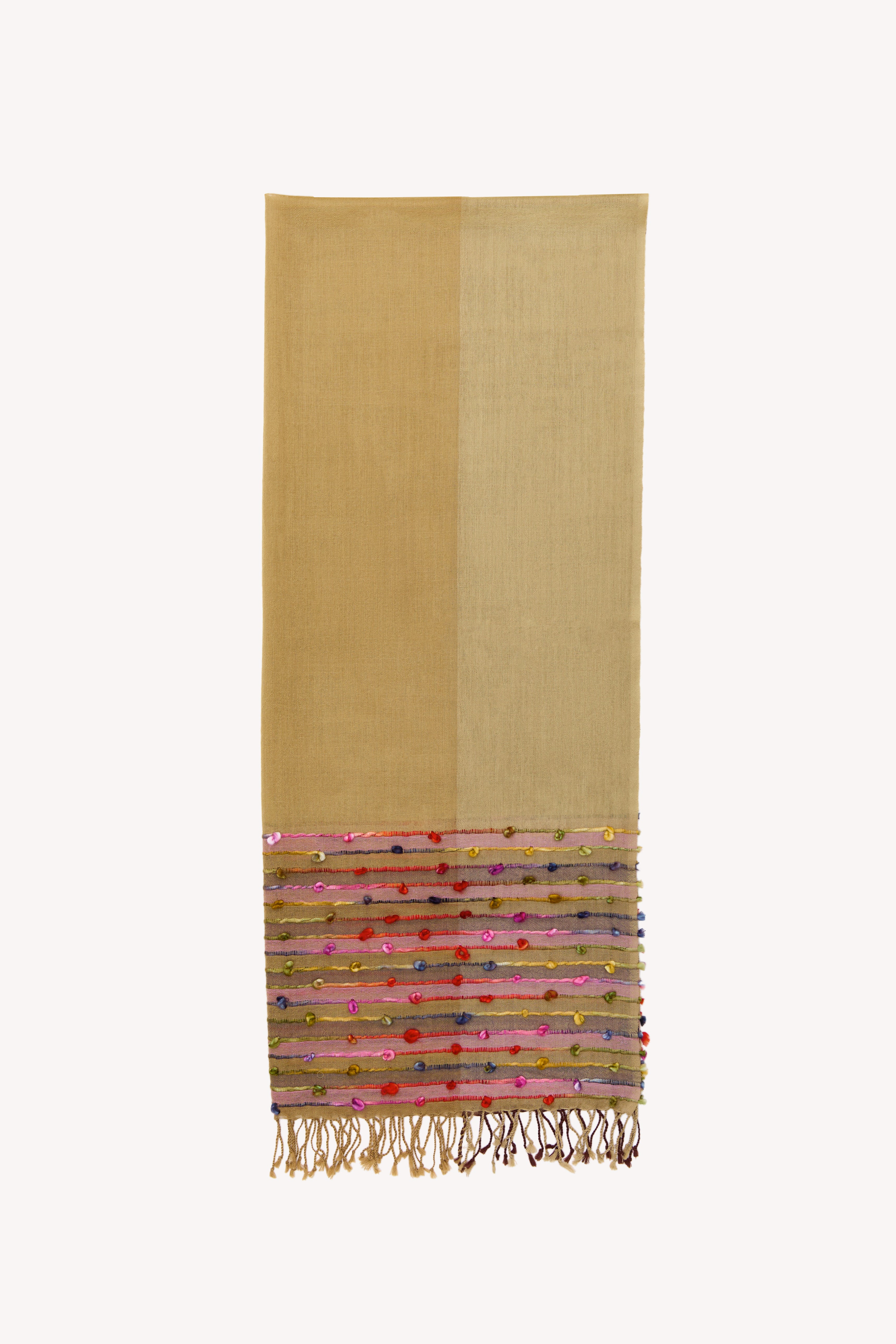 Nude handcrafted scarf on a neutral background.