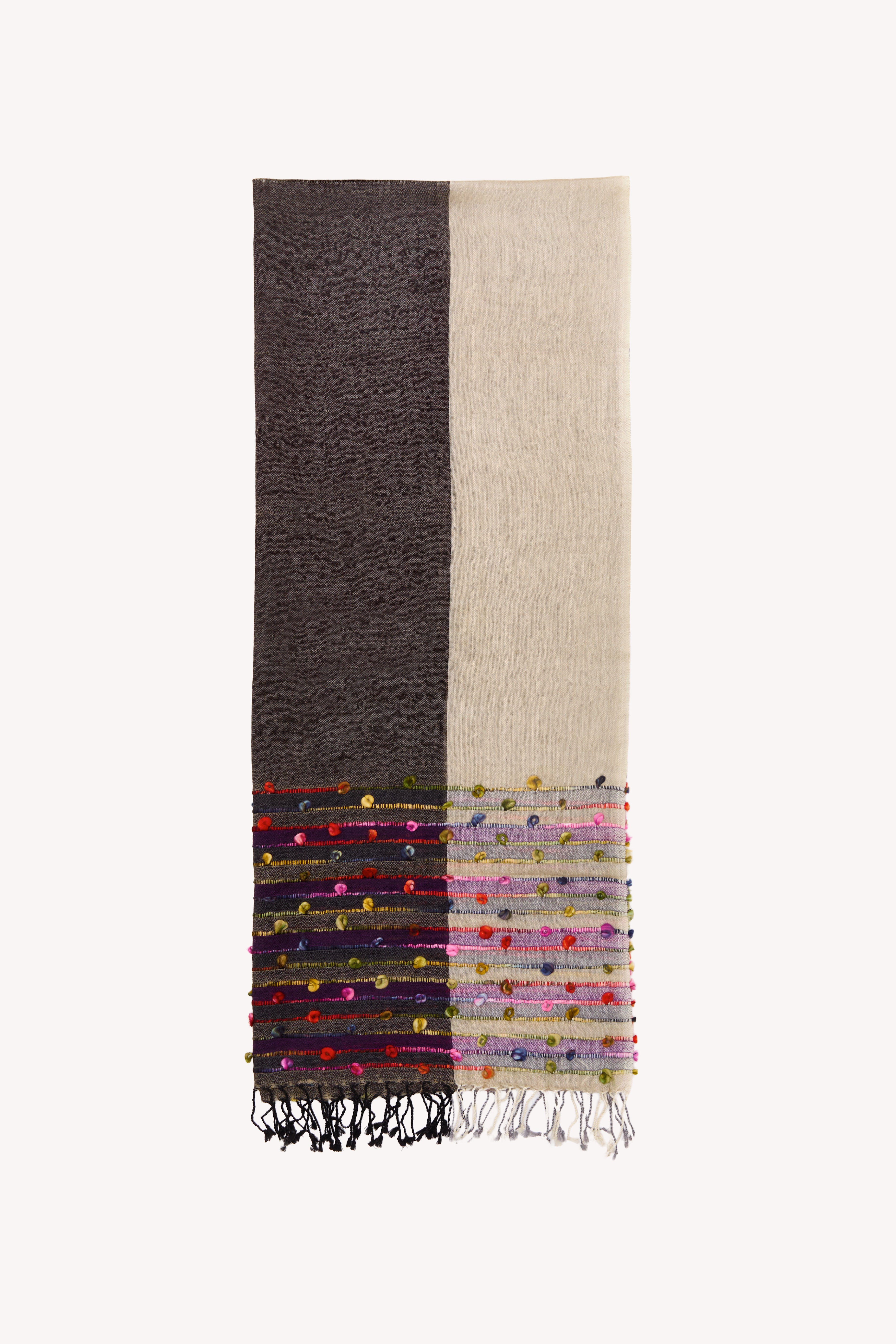 Grey and cream handcrafted scarf on a neutral background.